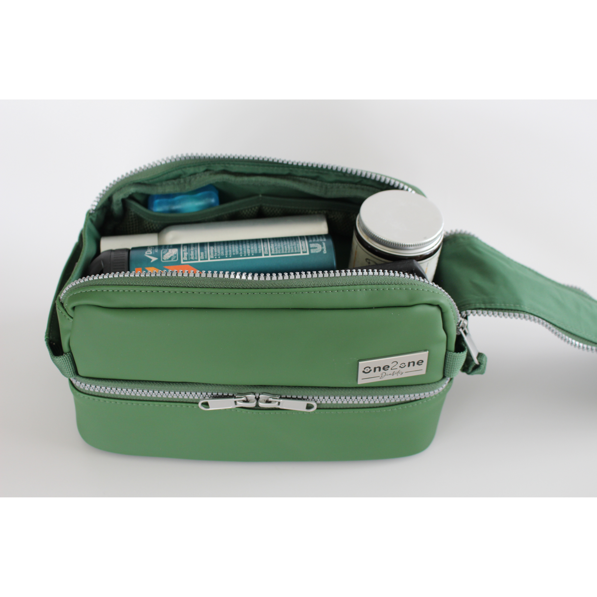 Top inside compartment of a green diabetes travel bag on a light gray background