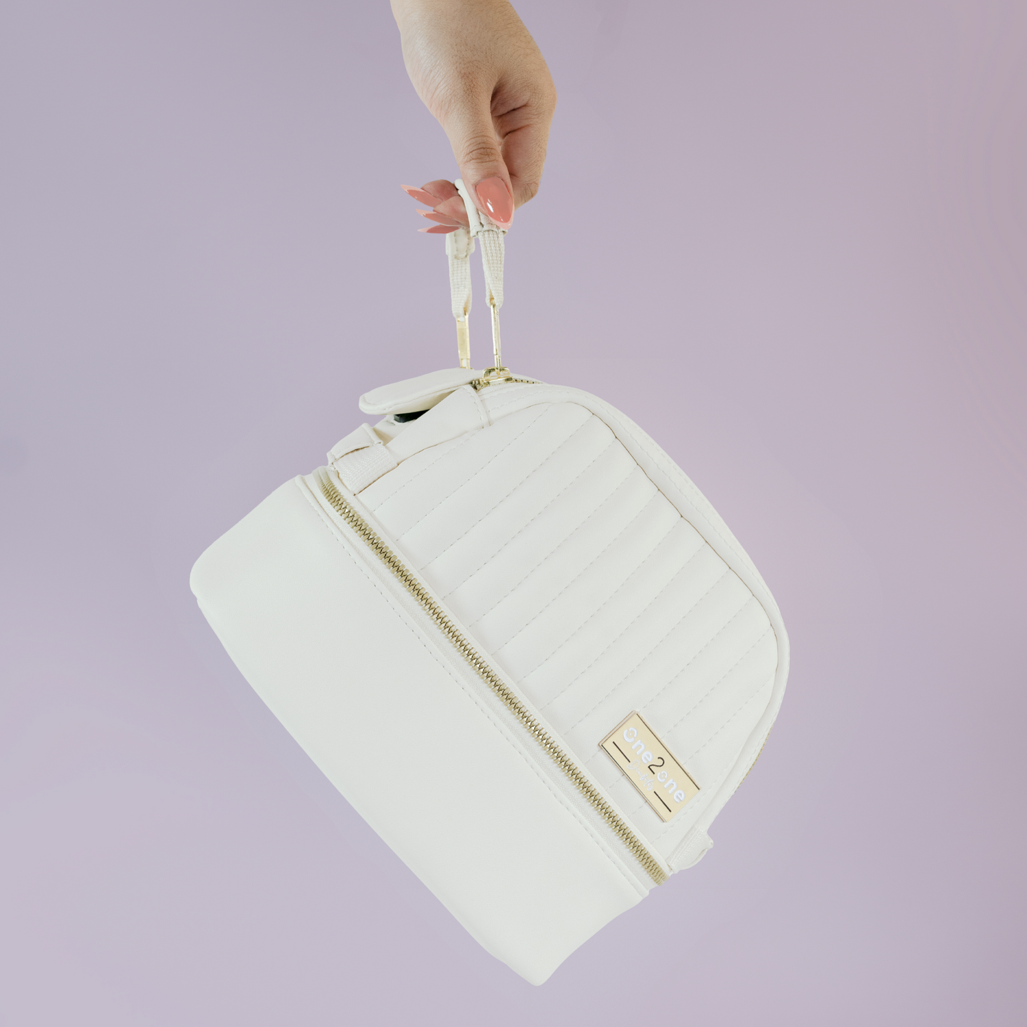 A woman's hand holding a small white diabetes travel bag on a purple background.