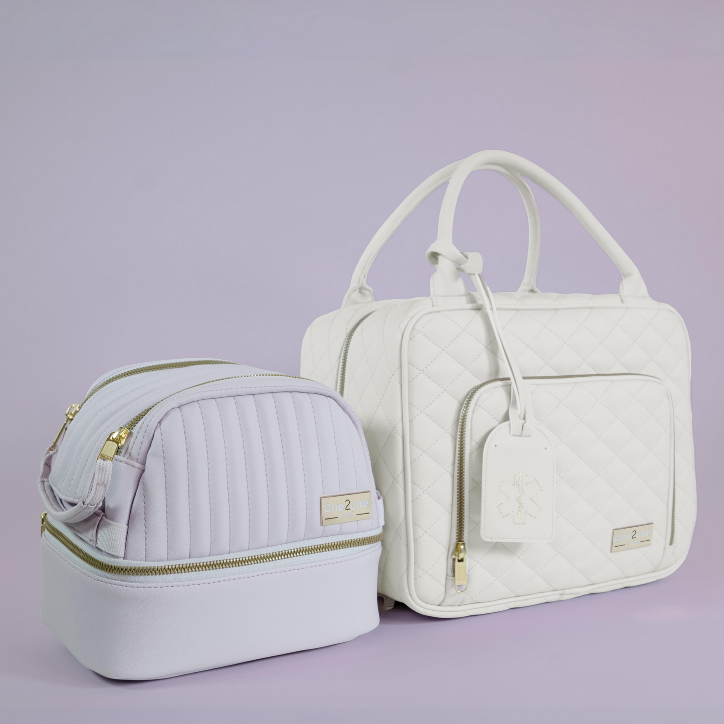 A small lavender diabetes travel bag next to a large white diabetes travel bag on a purple background.