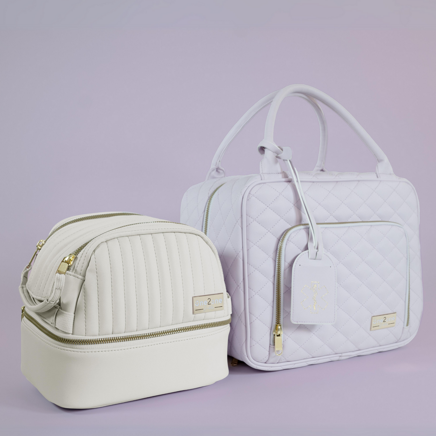 A small white diabetes travel bag next to a large lavender diabetes travel bag on a purple background.